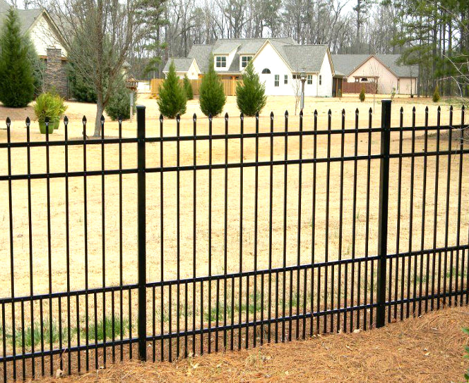 Black metal aluminum fence with spear top and puppy pickets in front of a house with trees and grass.