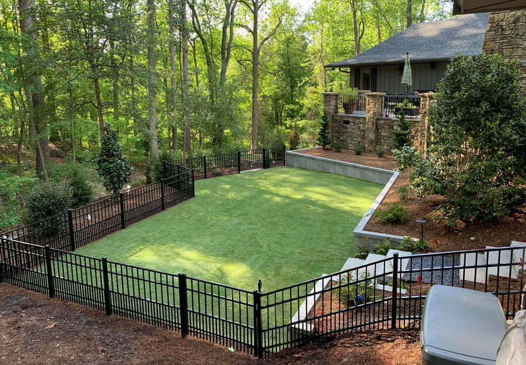 Backyard with puppy picket aluminum fencing surrounded by trees