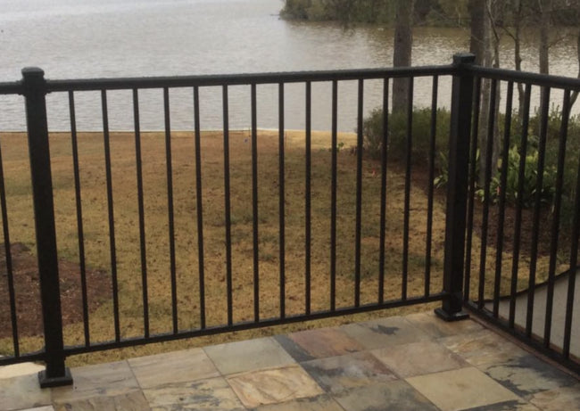 Aluminum post deck mounts securing an aluminum fence on a tiled patio