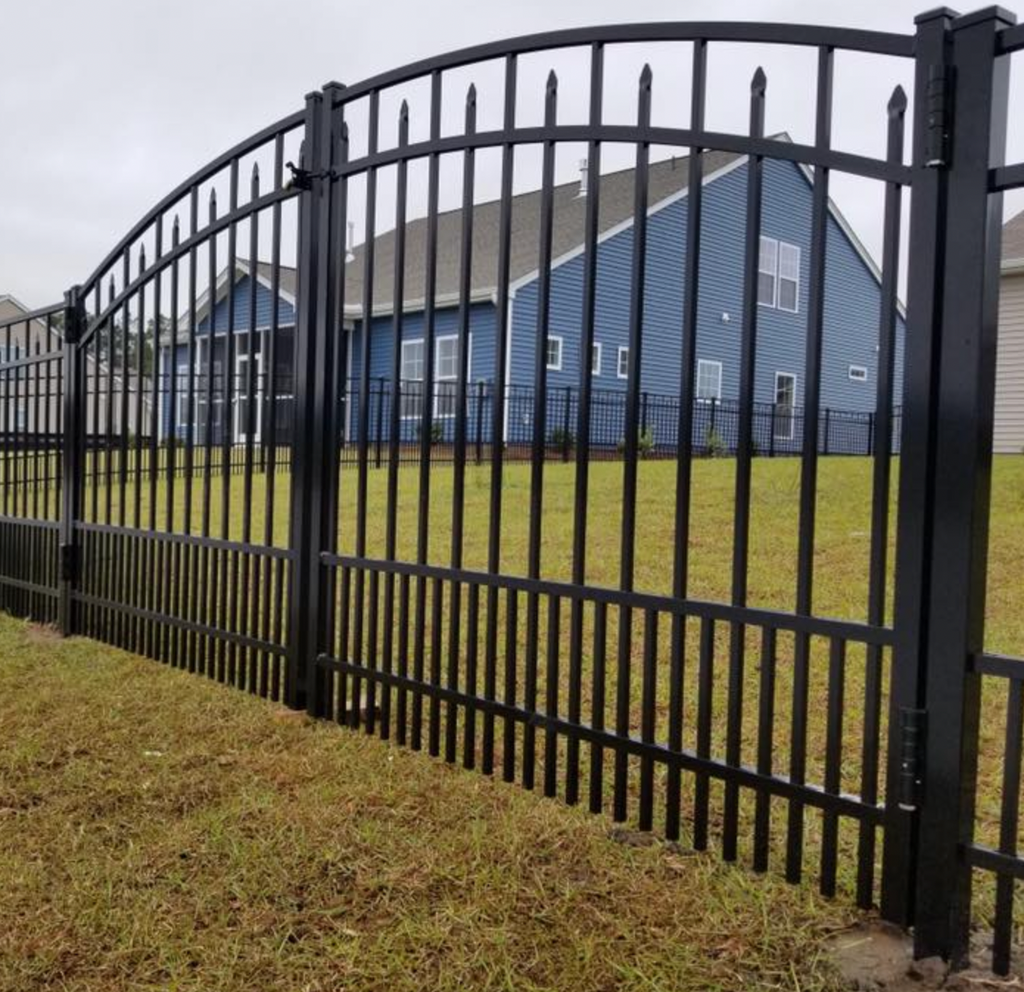 Black metal fence with pet security in front of a blue house with gray roof