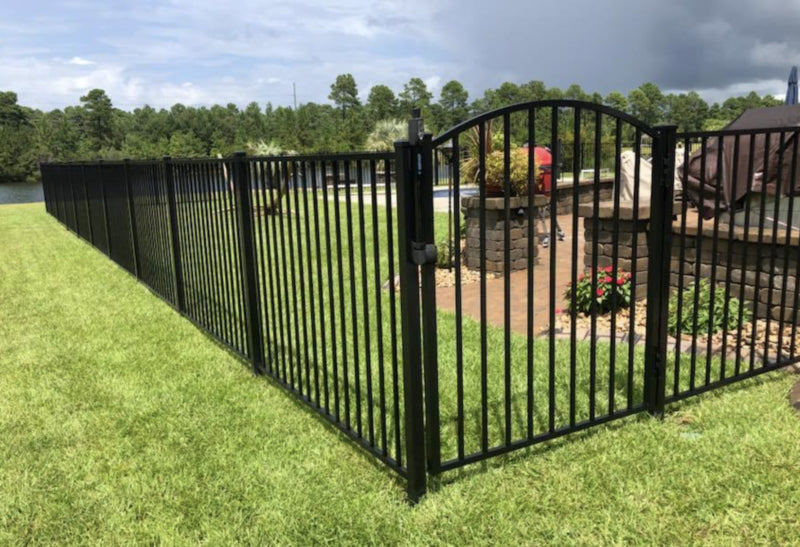 Black metal fence with a gate in a residential area around a pool