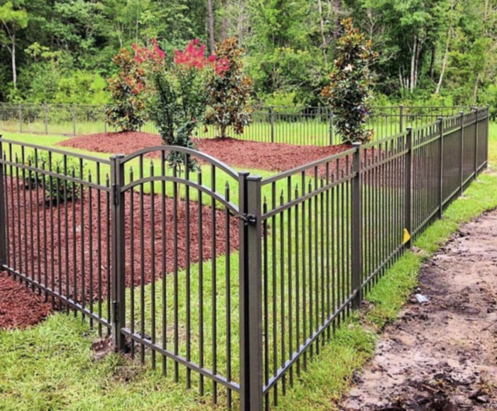 Metal fence with greenery and trees in the background
